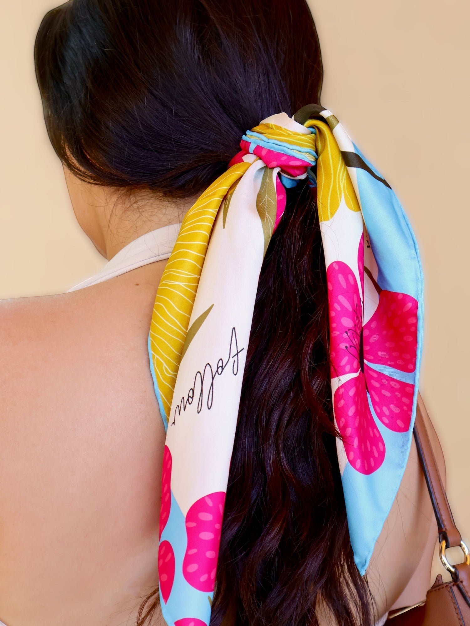 Wrap and Joy Mulberry Silk Scarf with fuchsia poppies, yellow blossoms, and blue border, tied in hair.